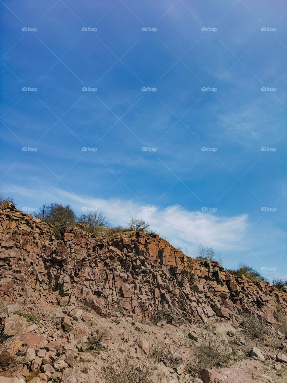 Granite rocks beneath the blue sky in sunny spring day