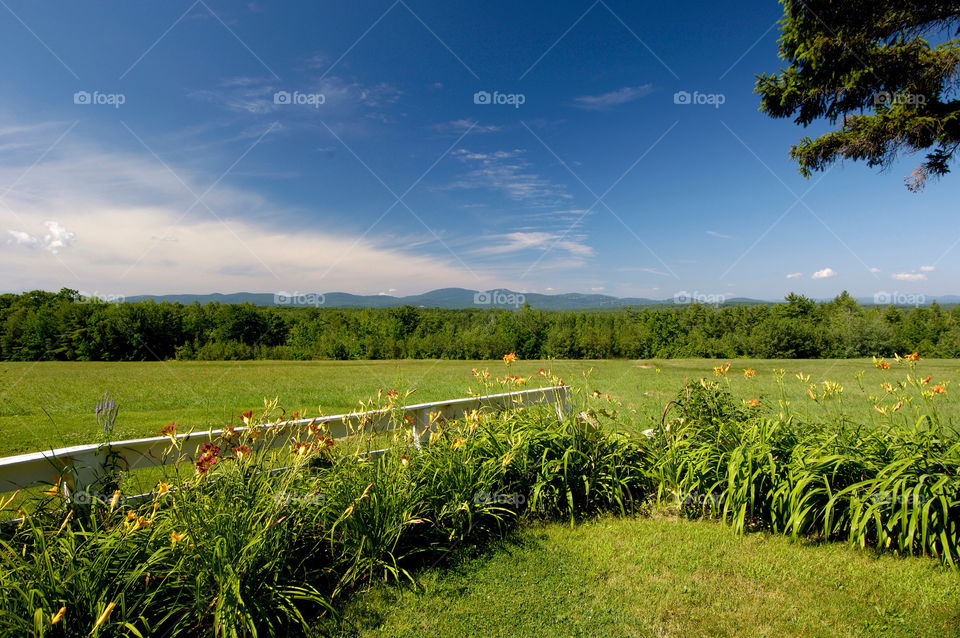 White fence on a field overlooking the mountains