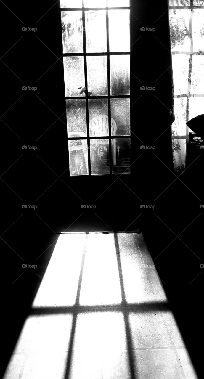sunset coming through door casting reflections and shadows in bnw