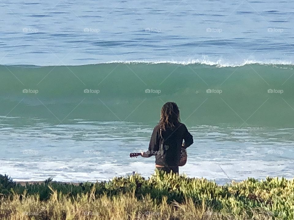 A Man His Guitar and the Beach 