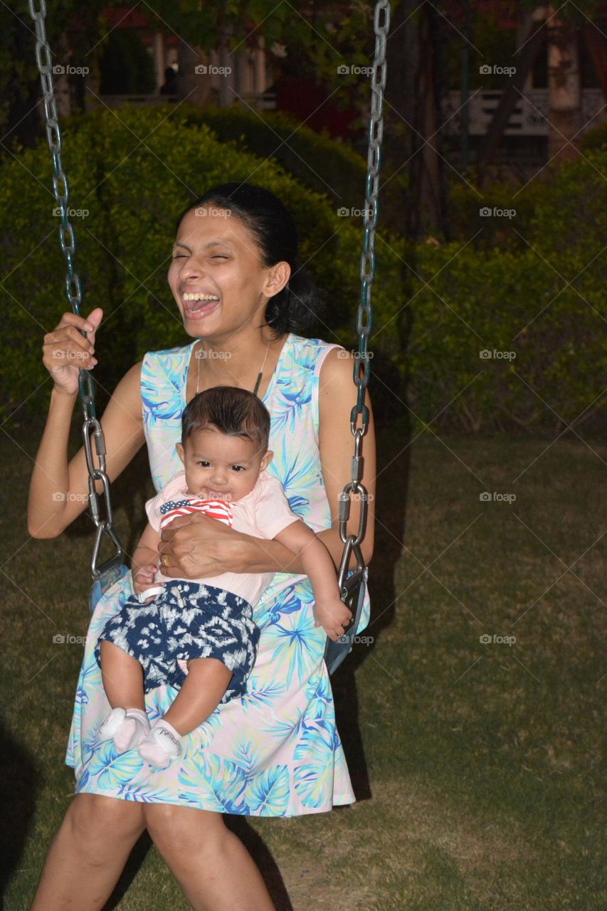 Mother Holding Baby for first Swing Ride - Happiness