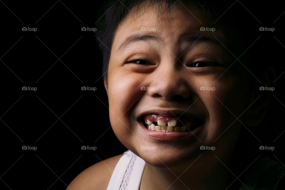 Portrait of smiling boy with black background