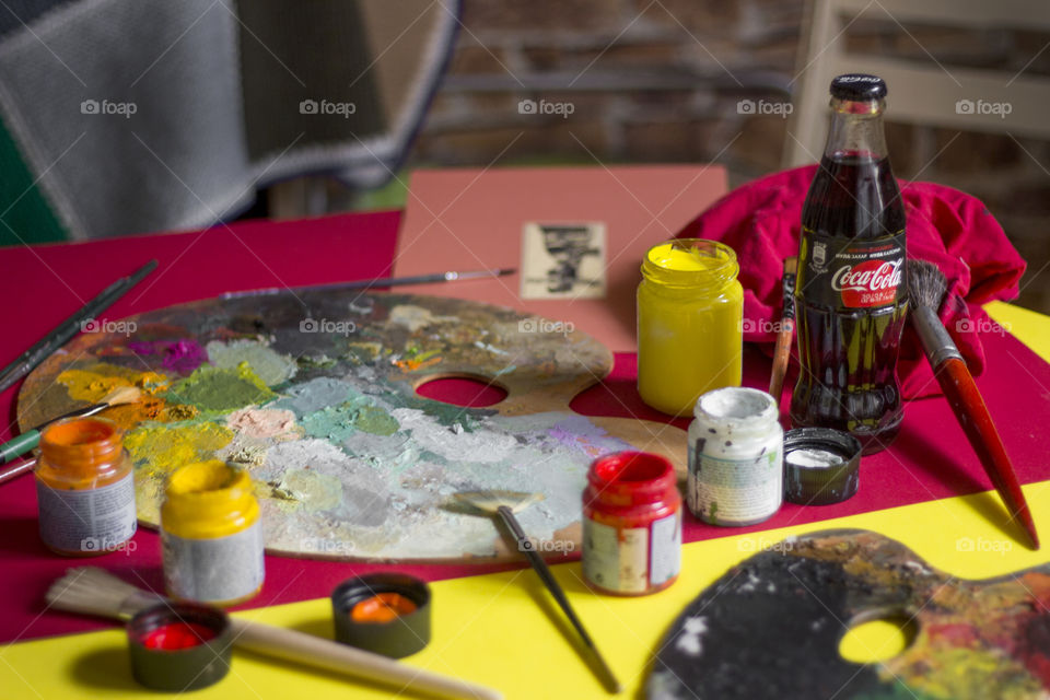 Coca-Cola bottles and colorful painting materials on the table