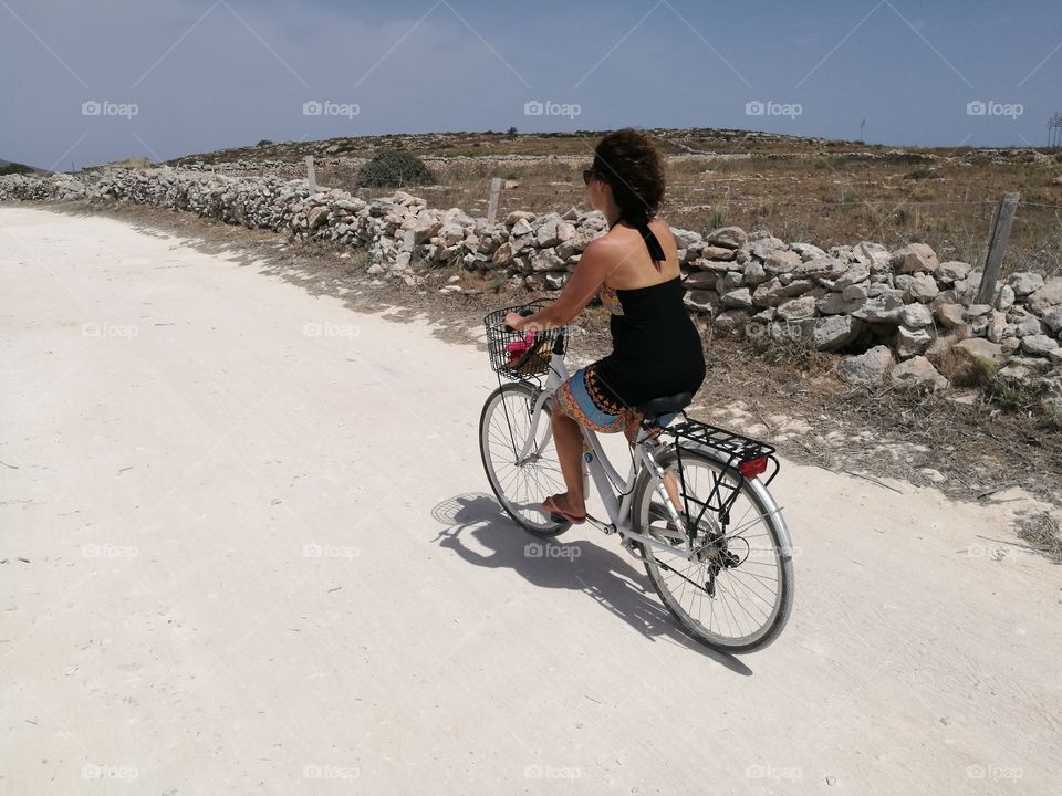 Woman walks by bicycle