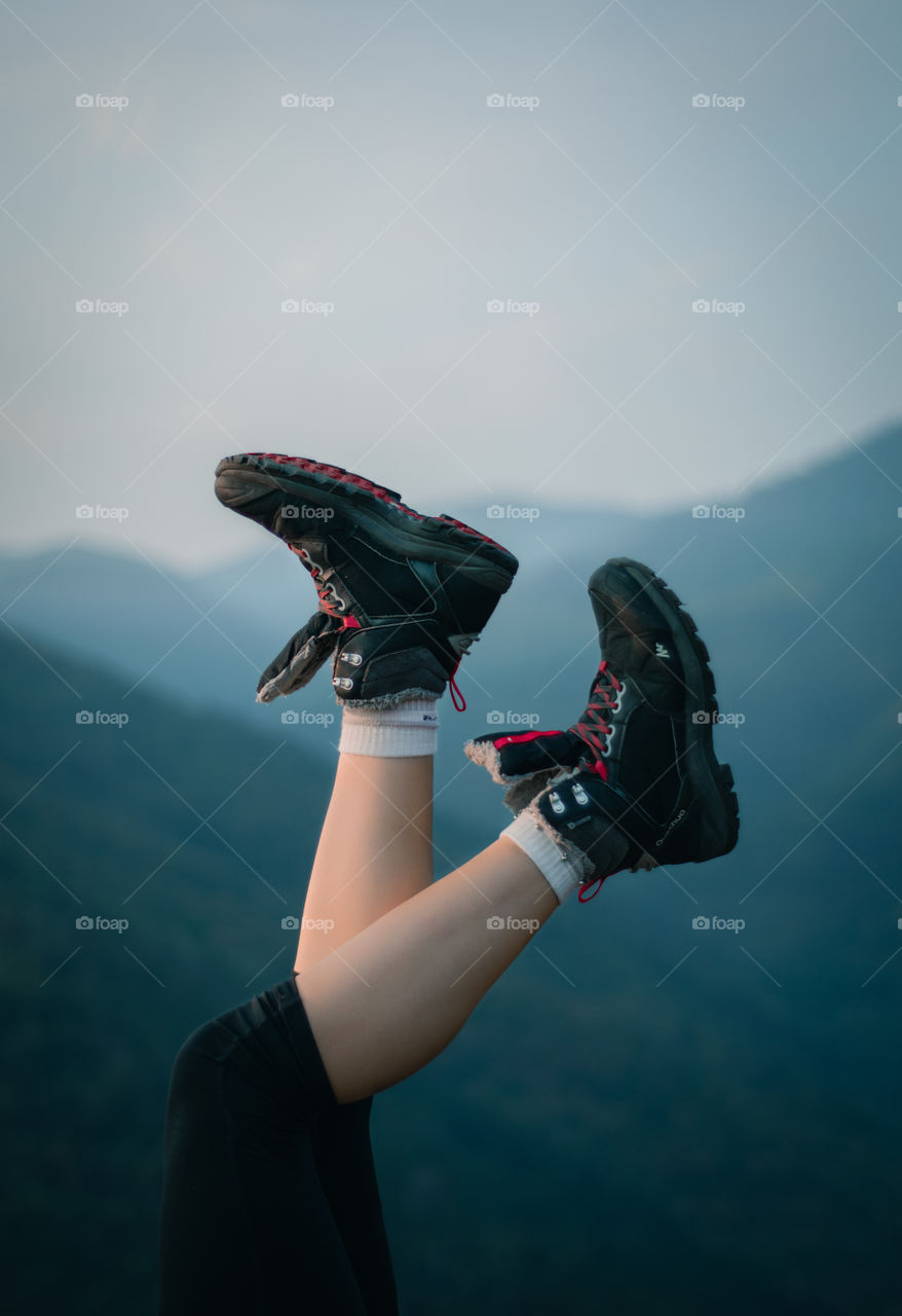 Woman with her legs pointing up in the mountains.