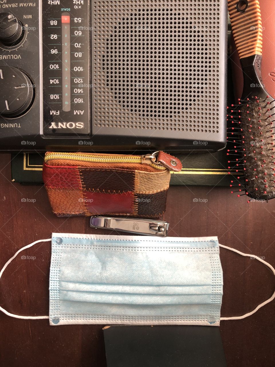 bedside cabinet of an old person in 2020, antique radio, comb, coin bag, face mask, nail clippers