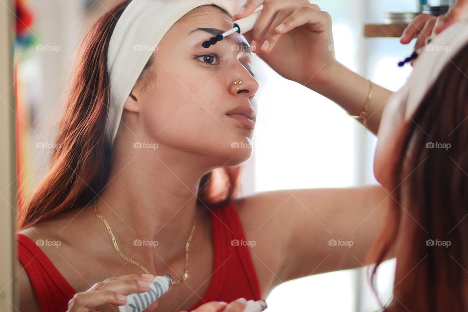 Young beautiful woman is using mascara