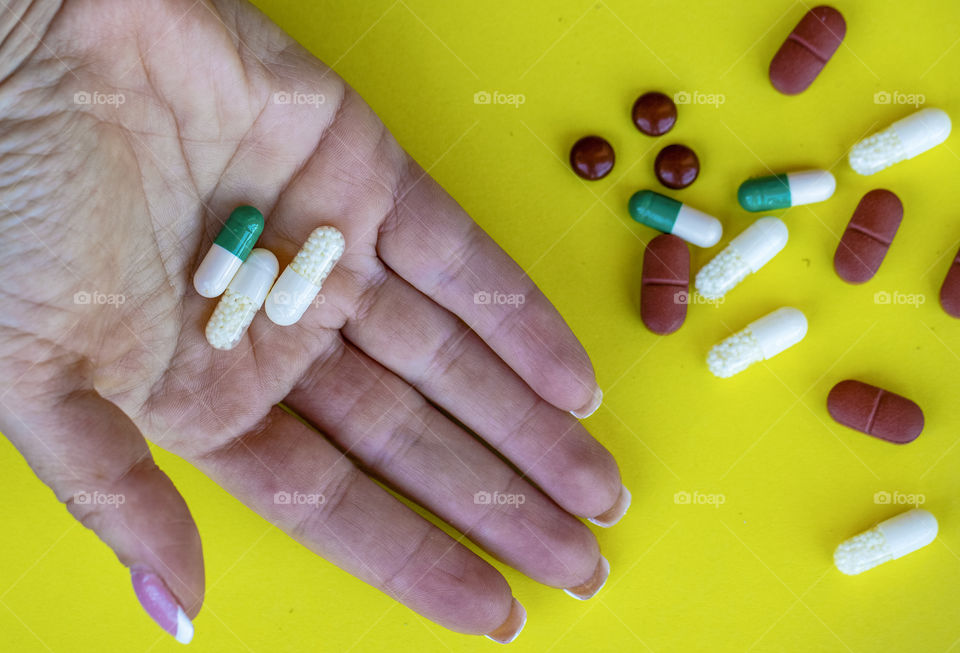 Female hand holding vitamins and pills