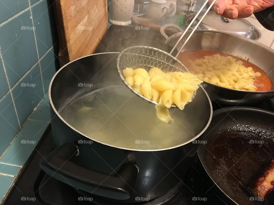 Scooping pasta to add to sauce 