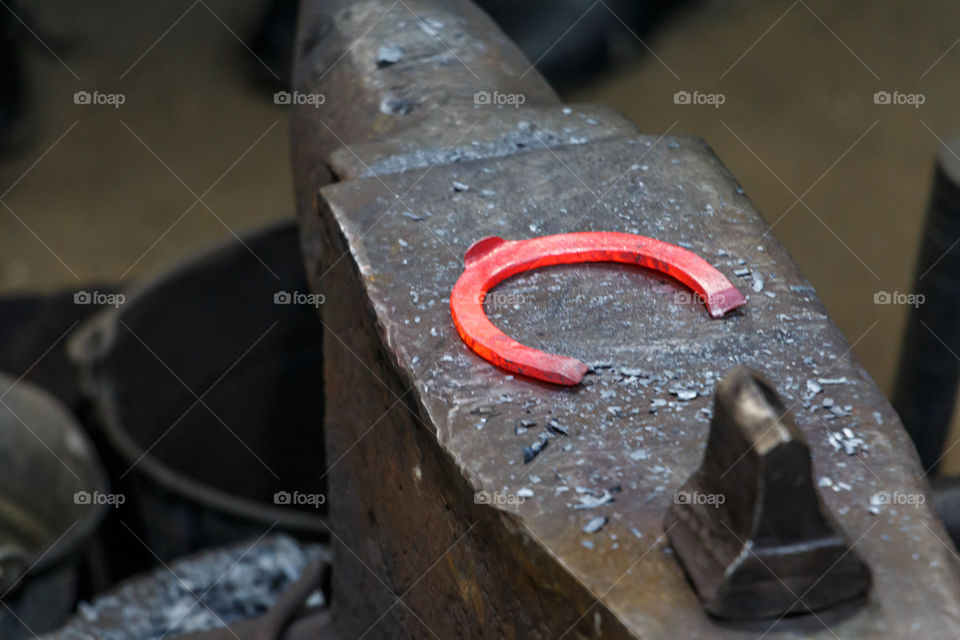 Blacksmith forges a horseshoe