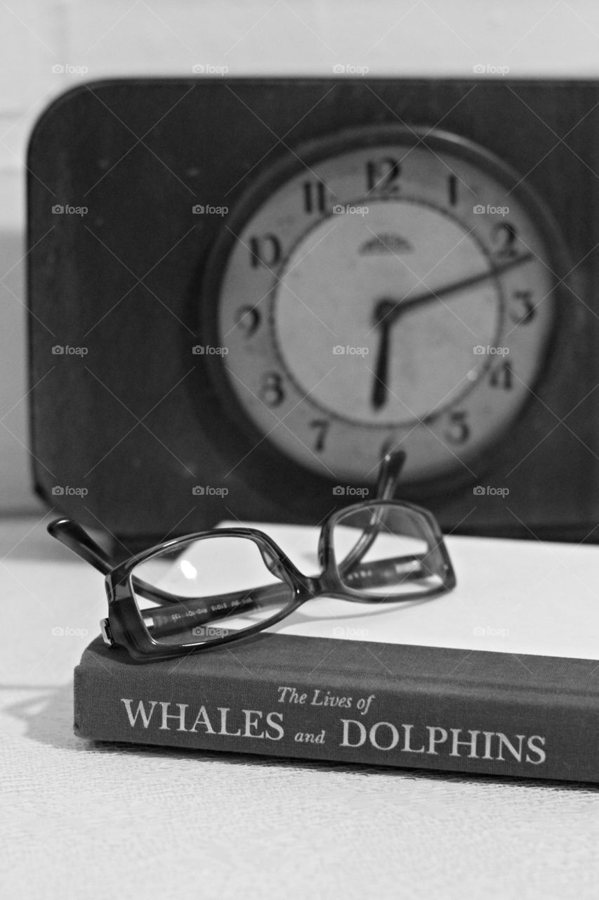 Book, eyeglasses and clock