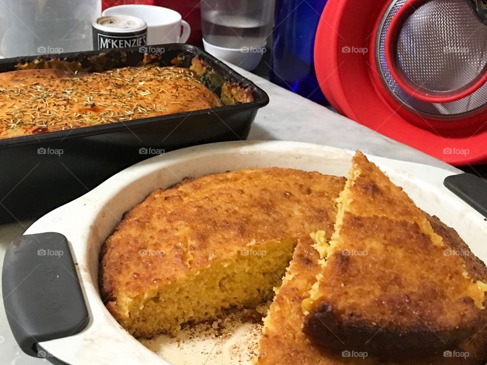 Traditional southern style cornbread in a round along tin, slice portion removed 