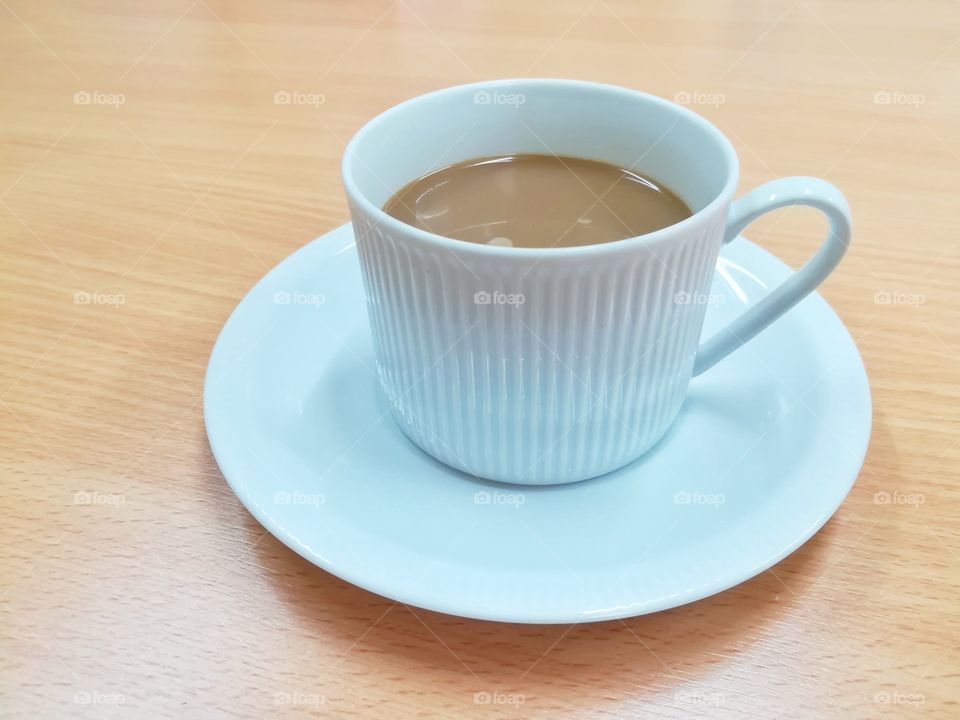 A cup of coffee on wooden table.