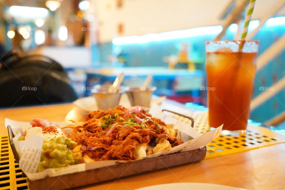 Mexican food served at the table of a mexican restaurante. Tacos of beef with michelada, a typical spicy beer from mexico