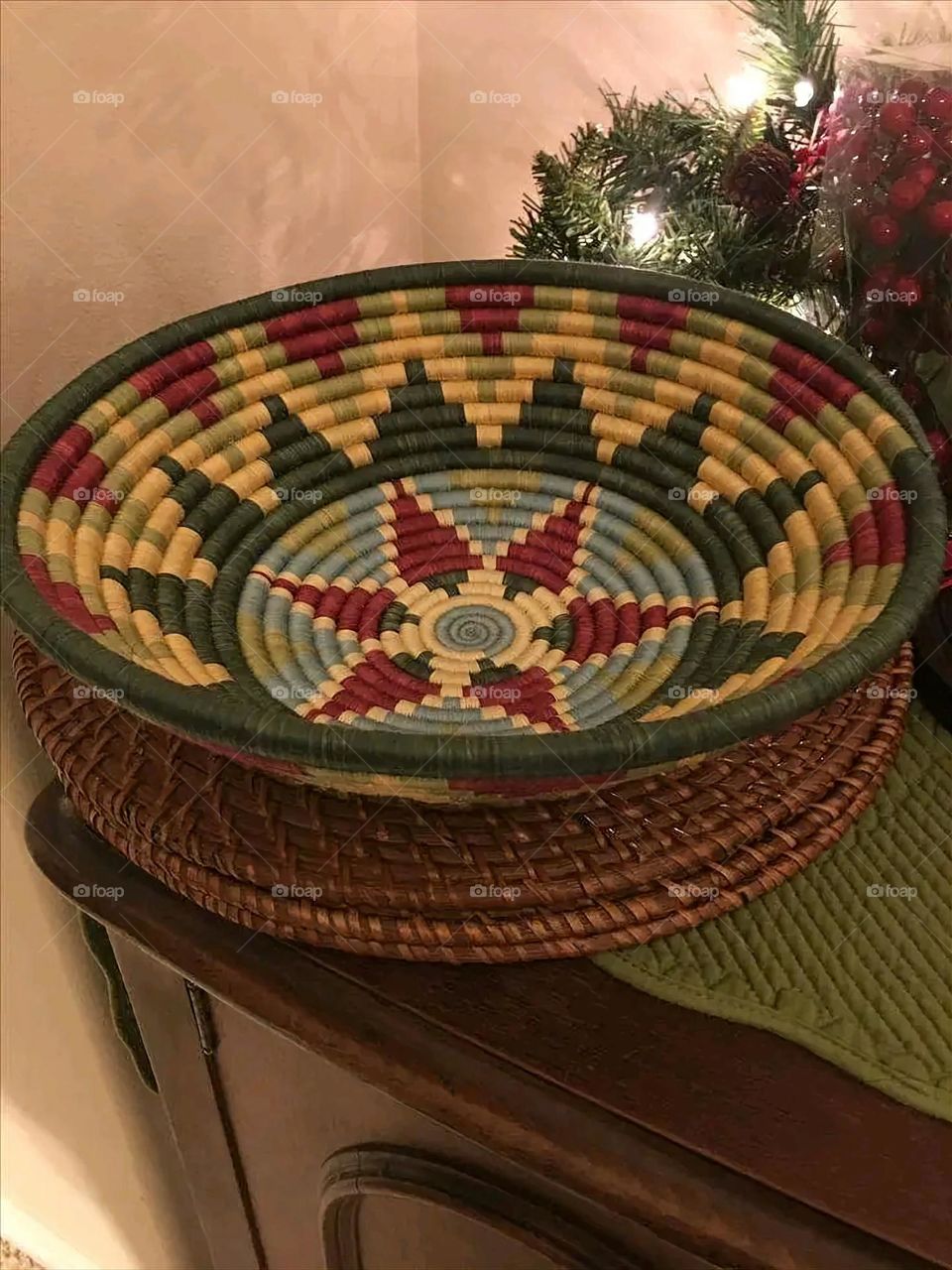 The image shows a group of hand -made dishes of wicker, decorated with colored embroideries with beautiful floral shapes, and is elegantly displayed in a warm corner that combines heritage and beauty, which gives the place an artistic spirit and attr