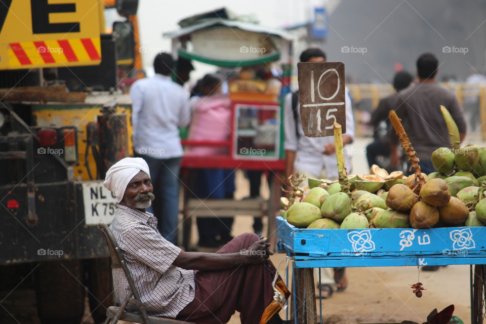 Senior man selling coconut