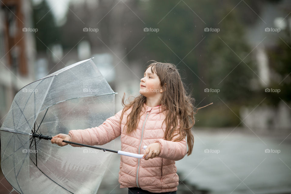 Little girl have fun under the rain.