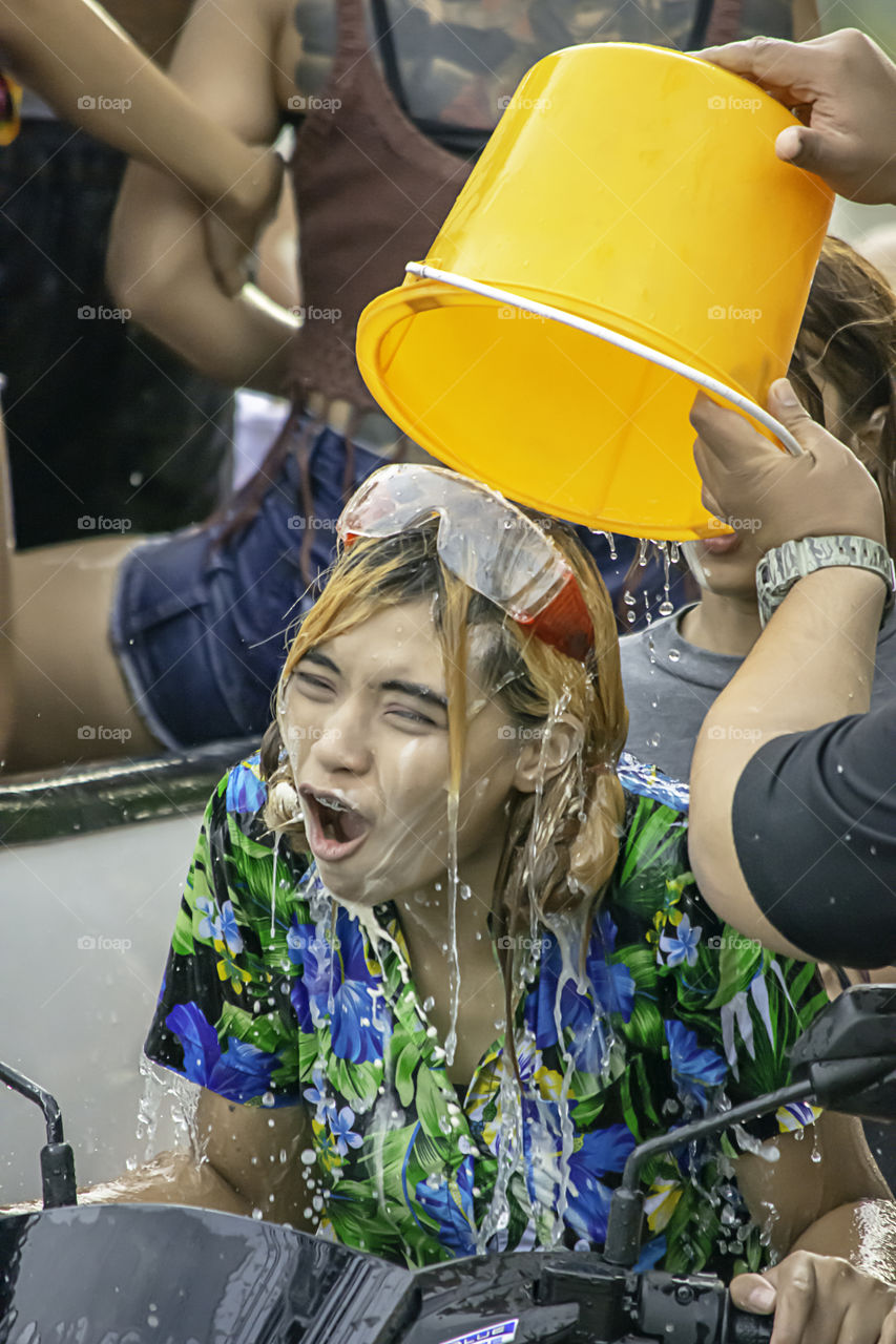 Asian woman Riding a motorcycle play water and flour in Songkran festival or Thai new year in Thailand at Bang kruai, Nonthaburi , April 15, 2019