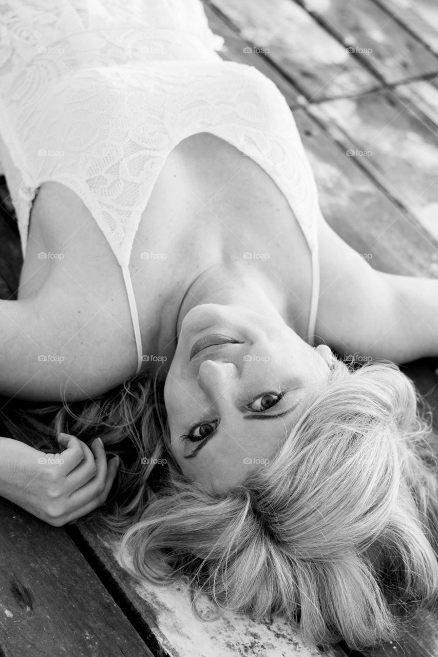 beautiful woman posing. woman posing while laying on wooden deck,monochrome effect.,.