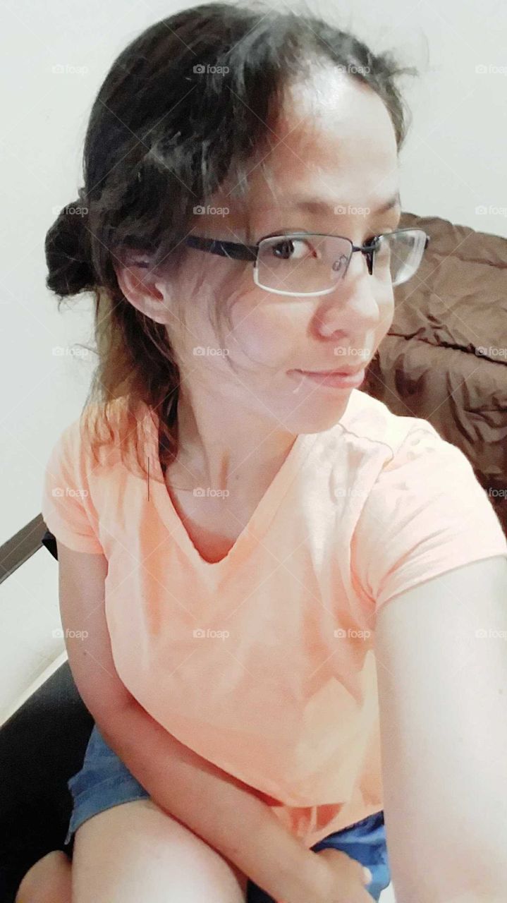 Seated photographer in peach tee takes a selfie