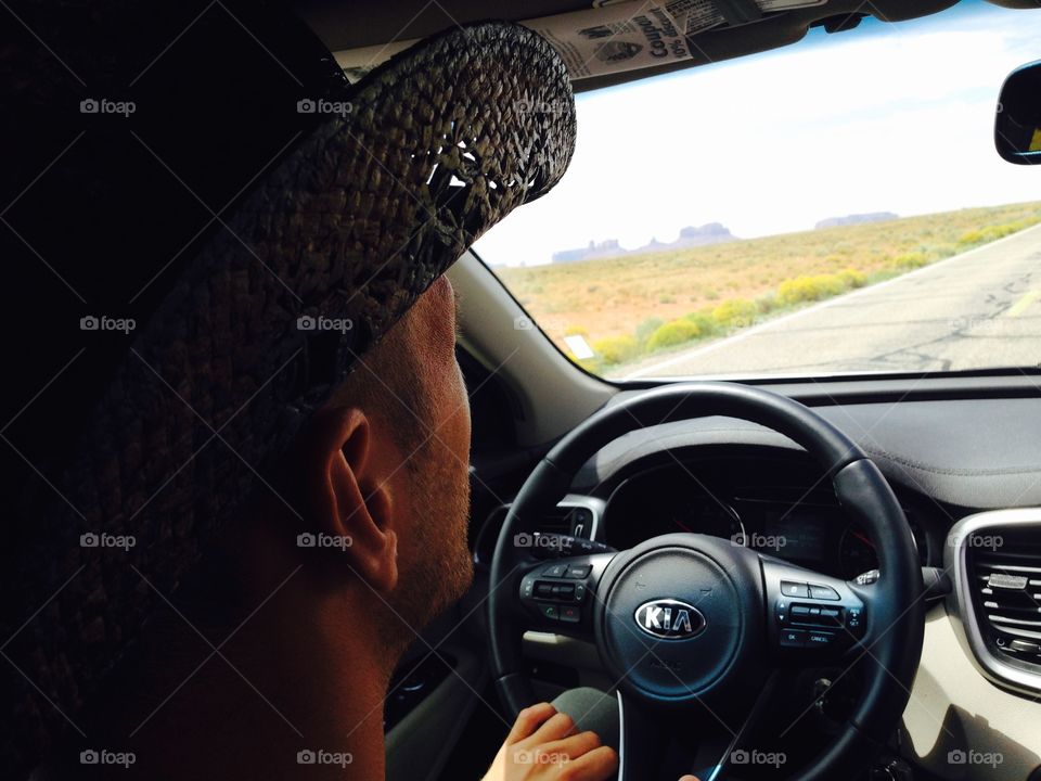 Behind a driver inside the car during his travel to Monument valley tribal park 