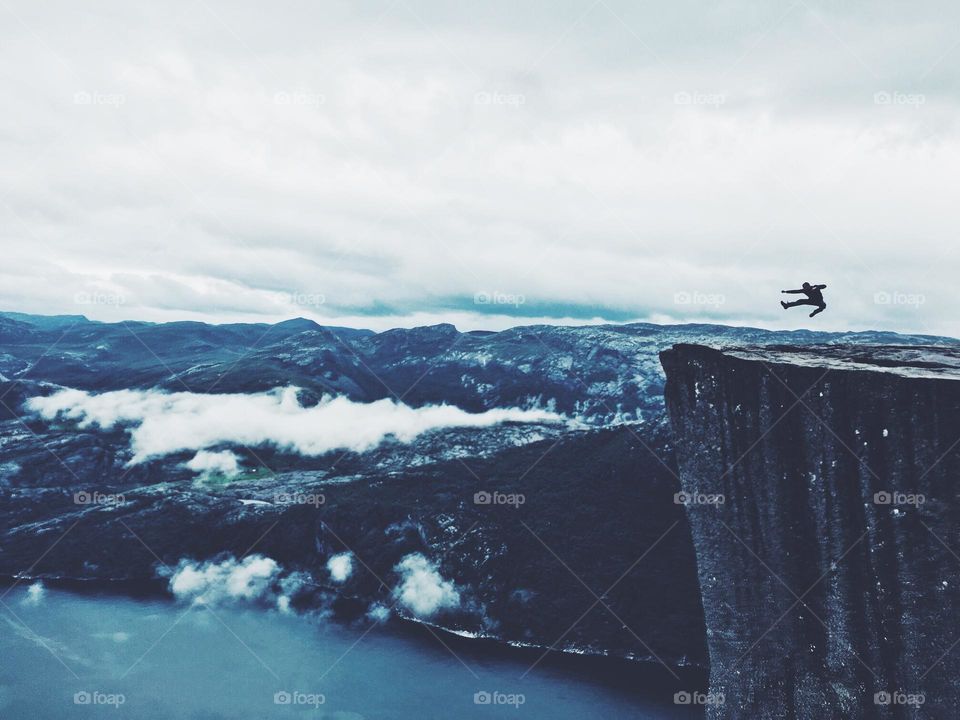 Inspiring jump on the edge of Prekestolen rock in Norway.