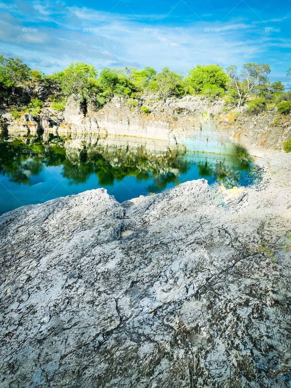 View of the lake with rocky banks and a reflection of the trees.