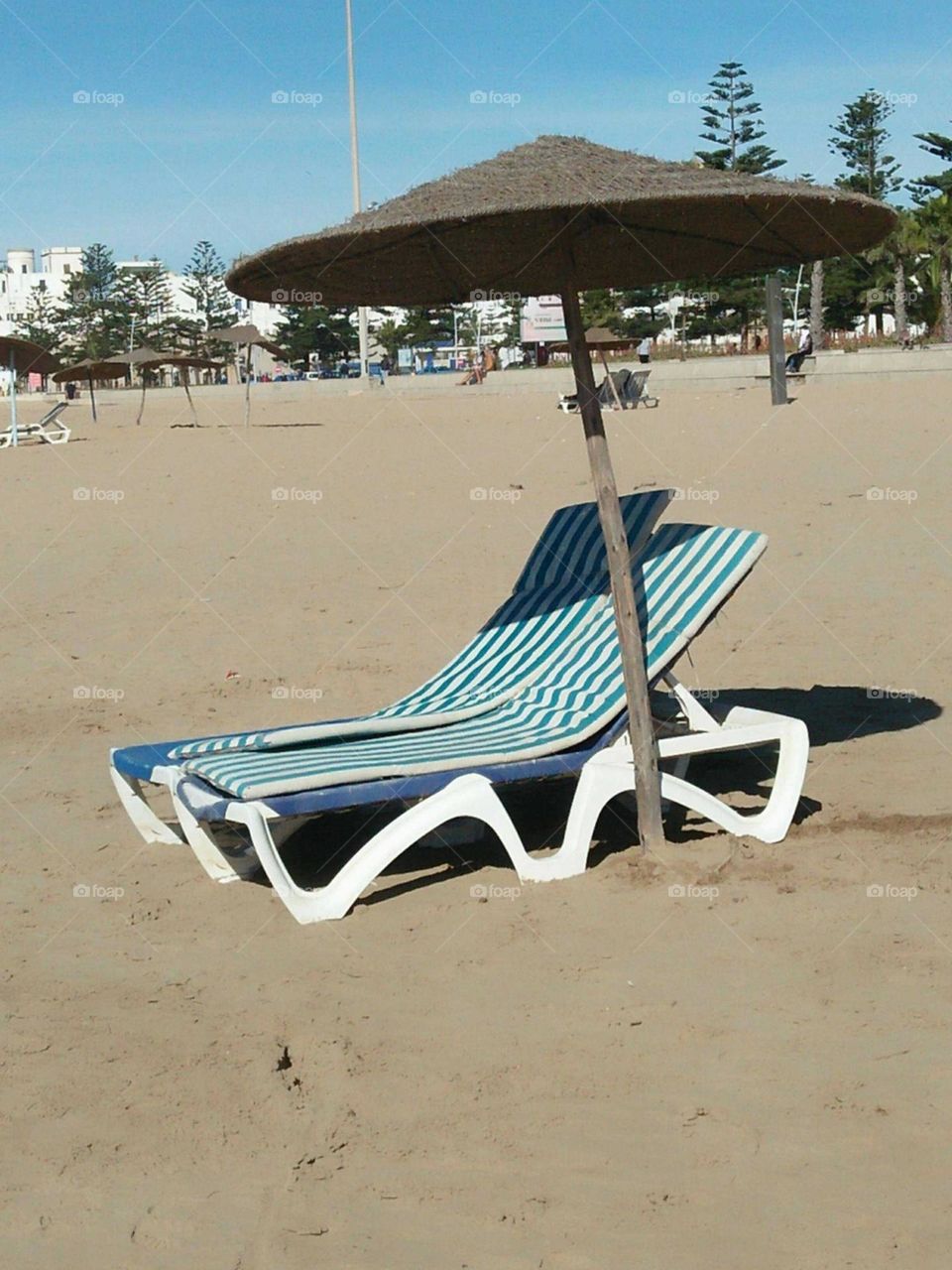 A good seat and beautiful umbrella at the beach.