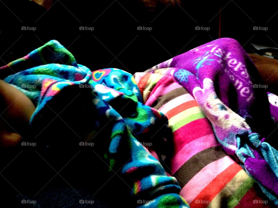 Hidden child. A child sleeps dressed in a plethora of colors