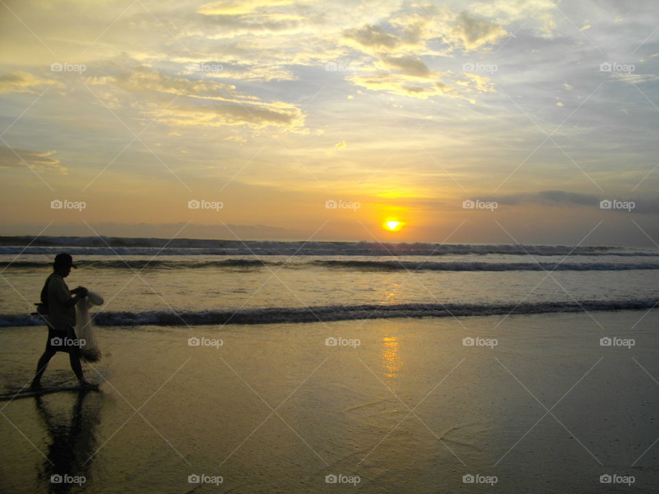 sunset and fisherman on the beach thailand