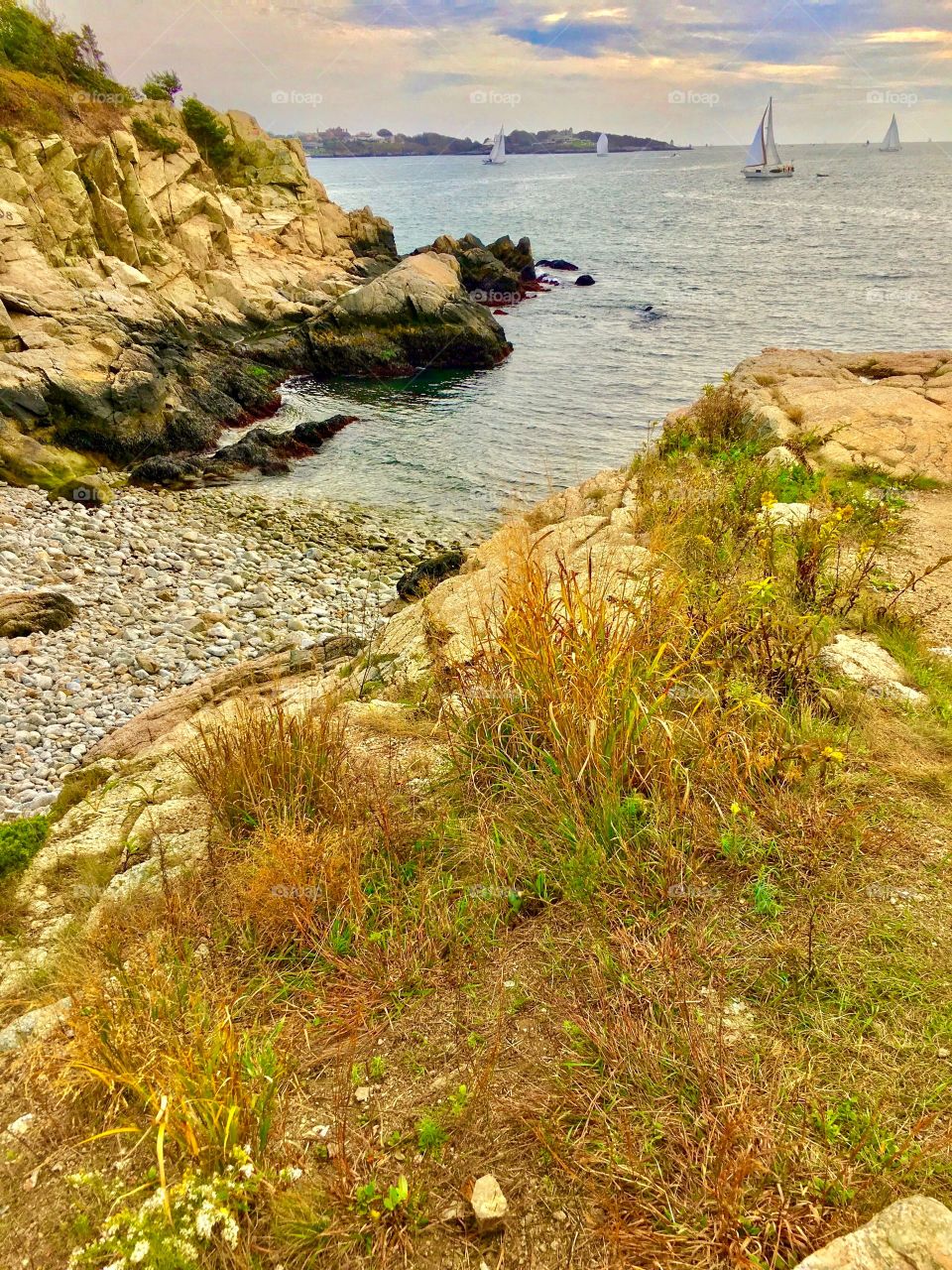 Rocky shoreline, cliffs and sailboats on the water in Jamestown, Rhode Island (Autumn 2017)
