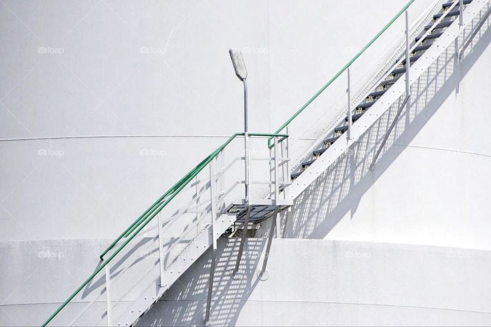 Stairs with railings on a white building in the sunlight and shadow pattern