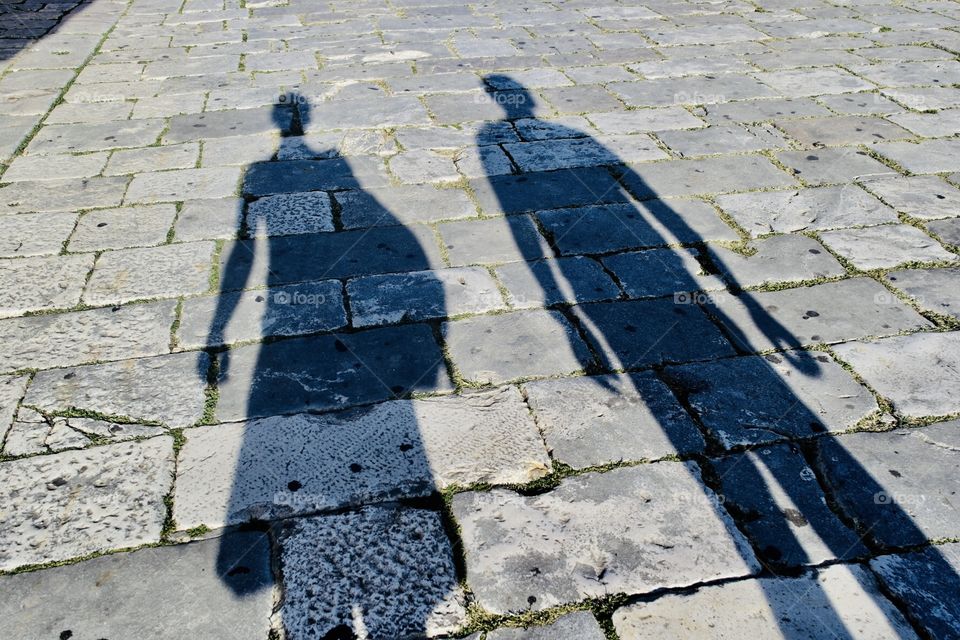 Shadow of a couple on a stone street
