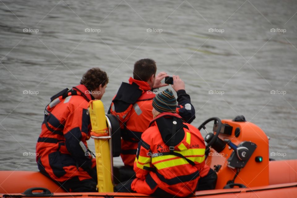 Rescue people taking pictures in the boat with a mobile phone