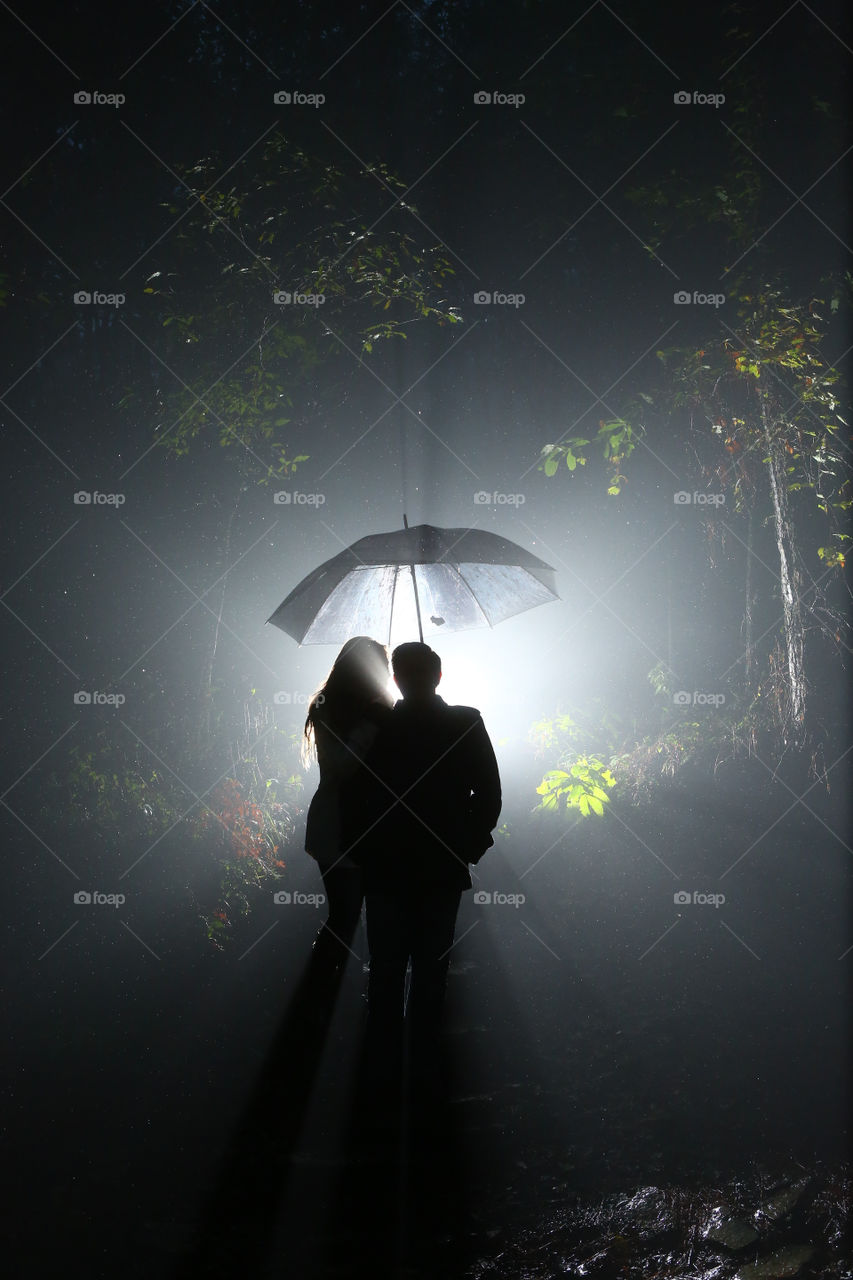 Couple hugging under the rain umbrella weather
