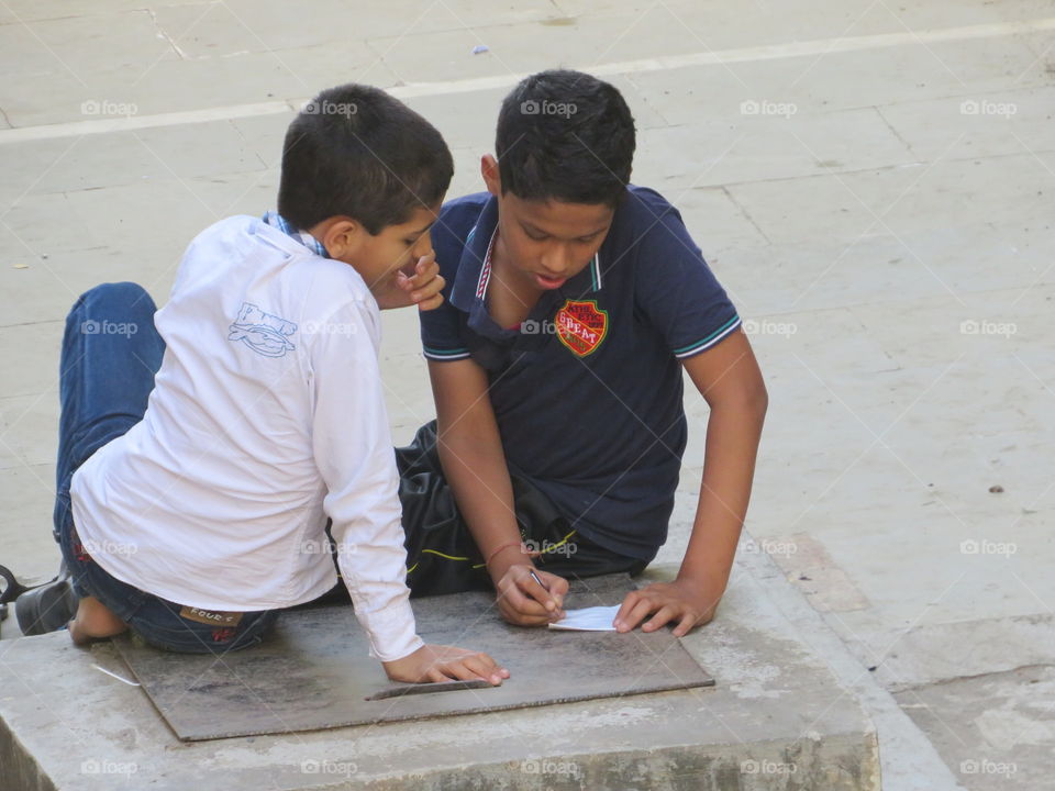 Boy writing on paper with pencil
