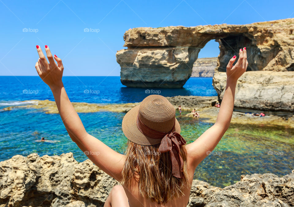 Rear view of a woman with a hat at malta azure