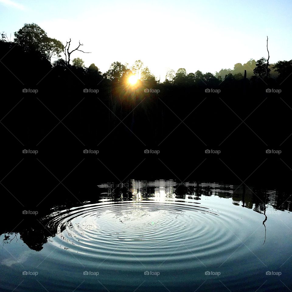 Circular waves in lake when sunrise
