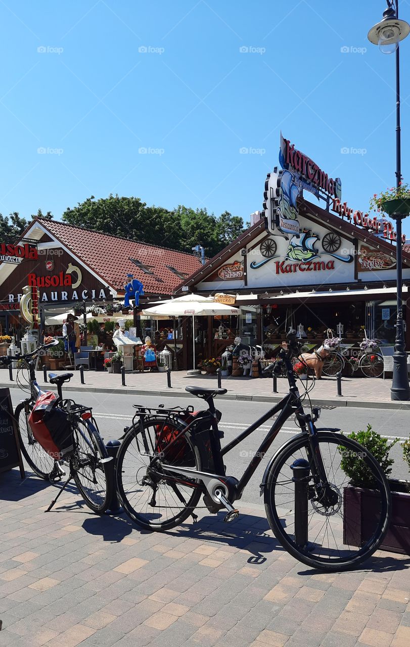 two bicycles on a street by a cafe