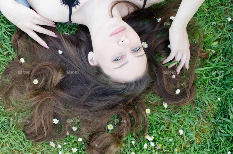 Woman with beautiful natural hair on background of daisies