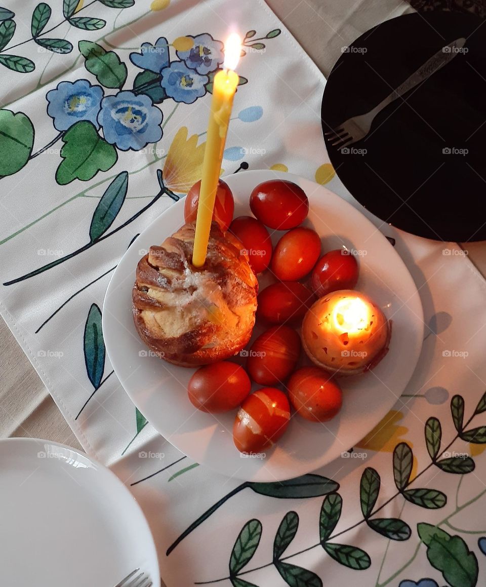Easter bread and Easter eggs with a lit candle
