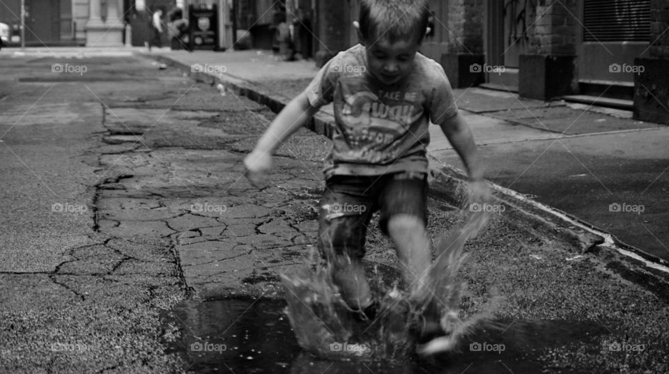 Little boy playing with water in the streets of New York 