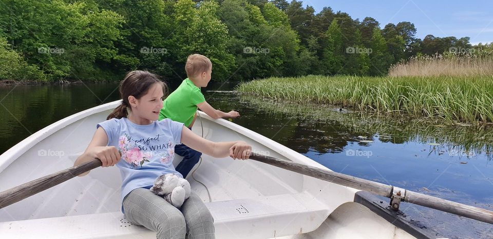 A girl gives a boy a ride on a boat. Children ride on a boat. Tallinn, Pirita river