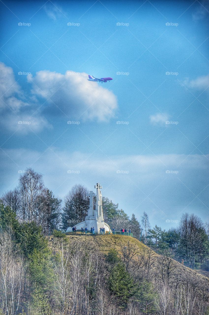 Three crosses monument, plane above and many people visiting place