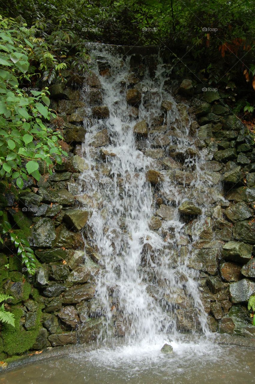 Waterfall. Small waterfall over stone wall