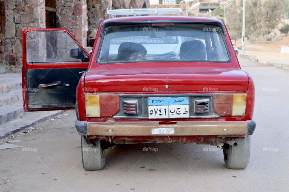 Red car in desert village 