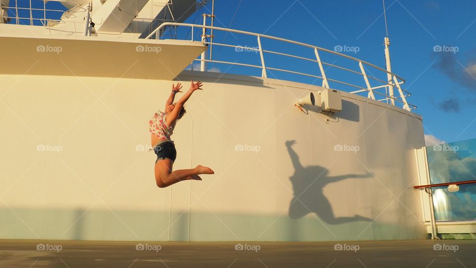 Young girl jumping at ship's deck