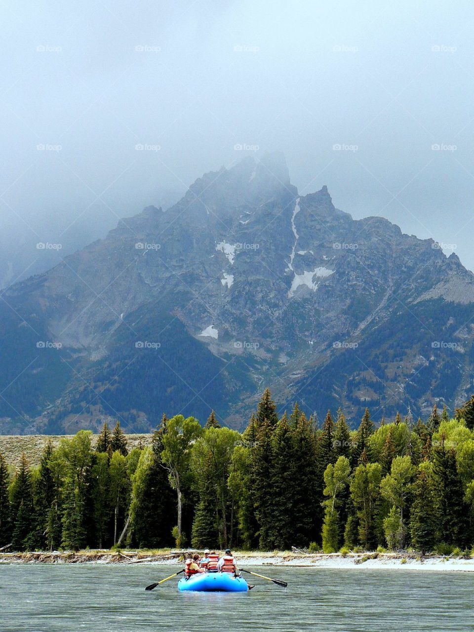 Tetons touching clouds. The grand Tetons poking into the clouds with the boat below