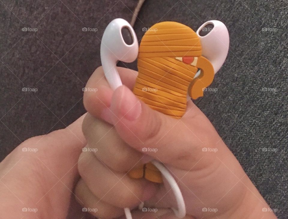 Hand holding earphones and a mummy earphone organiser