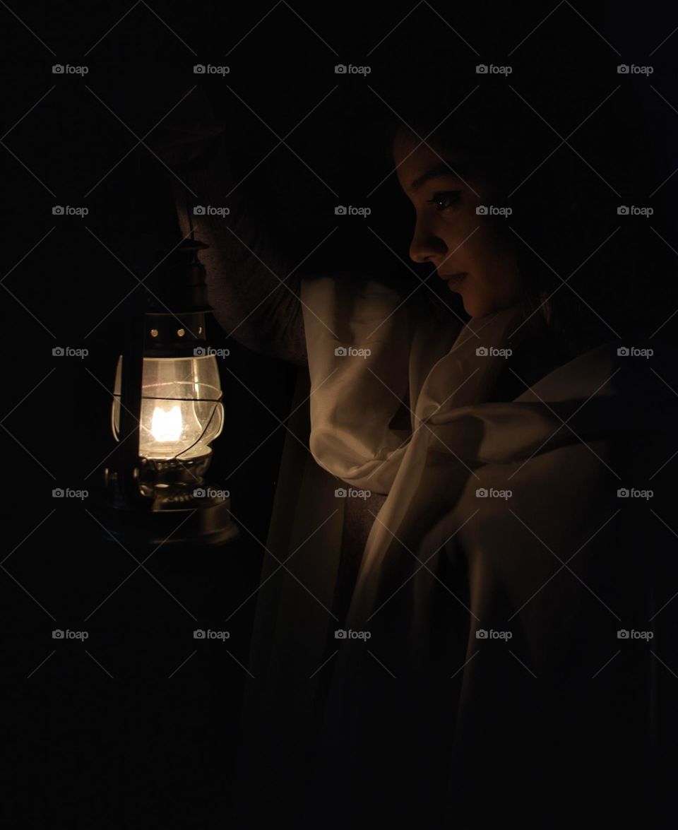 A girl with a lantern in the dark